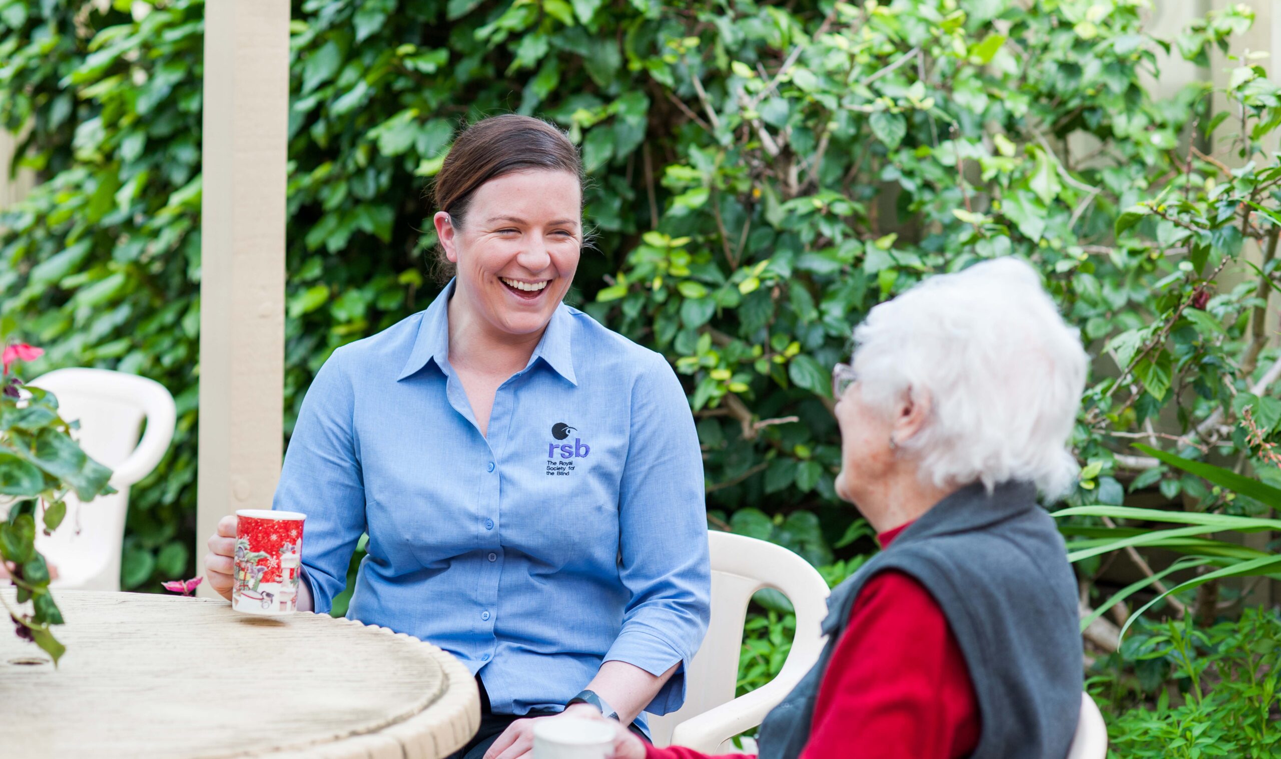 Royal Society for the Blind Occupational Therapist laughing with a client over coffee